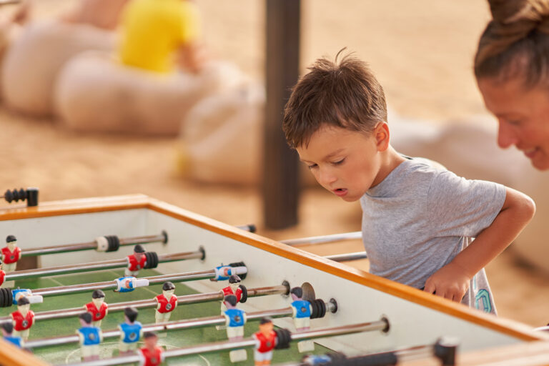 Mother plays table football with sons in Egypt Hurghada. High quality photo
