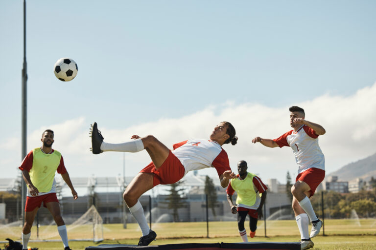 Sports, soccer and soccer player with team and soccer ball in power kick while playing on soccer fi.